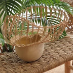 Vase en céramique beige avec tressage en fibres et herbes vertes