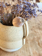 Vase en céramique beige moucheté avec anses et fleurs séchées bleues