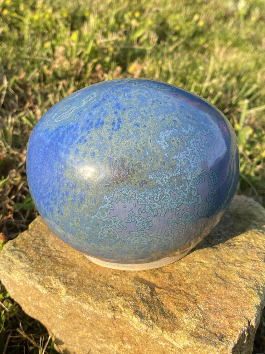 Pierre décorative ovale bleue veinée, reflets brillants, aspect marbré.