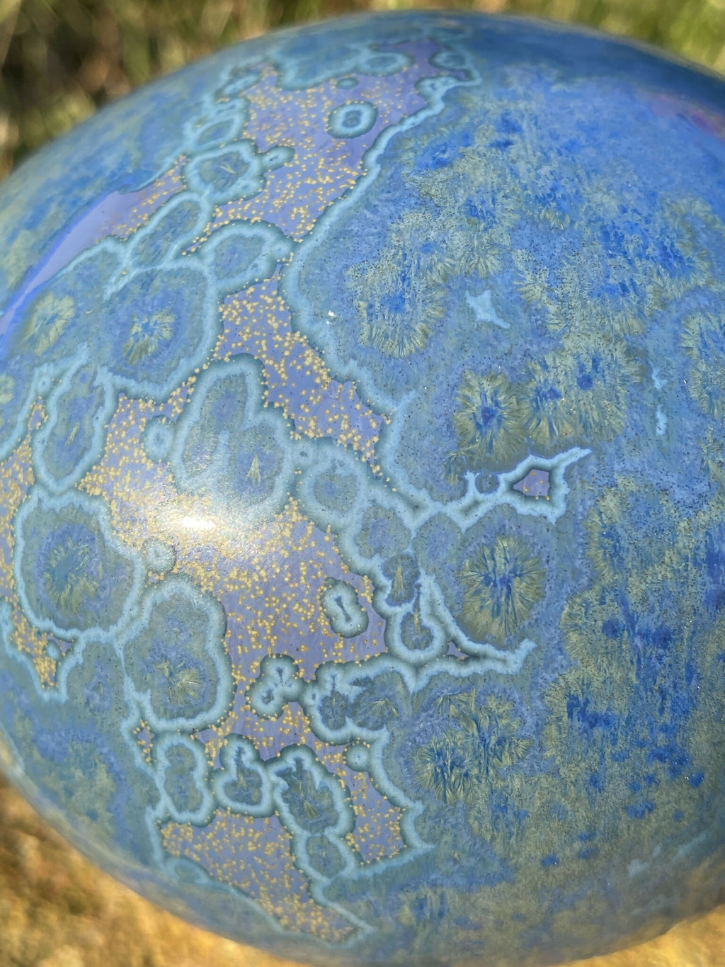 Pierre décorative ovale bleue veinée, gros plan motifs type cartographie bleu clair.