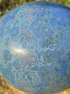 Pierre décorative ovale bleue veinée, gros plan motifs type cartographie bleu clair.