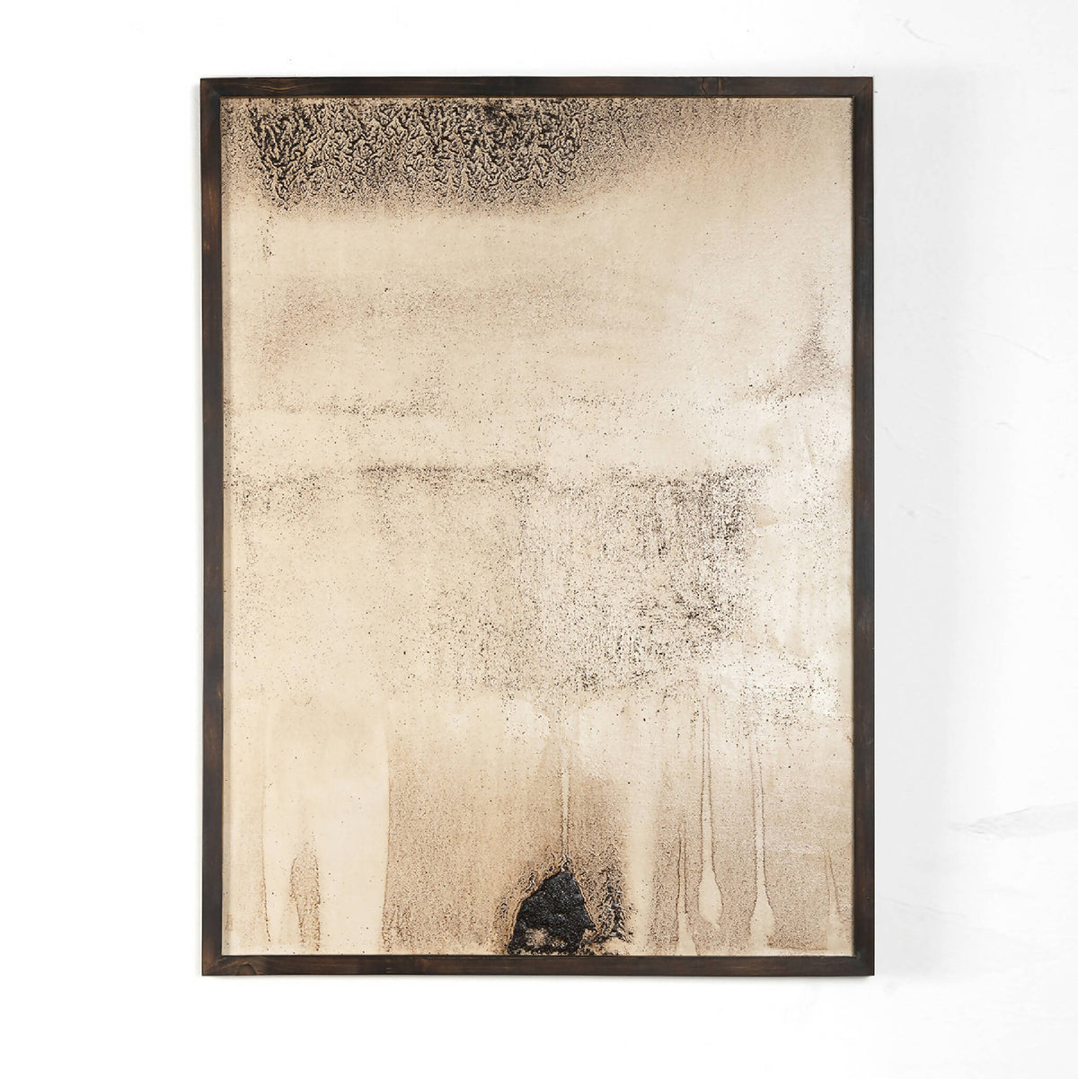 Œuvre originale abstraite encadrée, fond beige clair, texture granuleuse et tache sombre en bas.