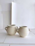 Paire de pots en grès beige clair, anses, forme ronde, vue de face