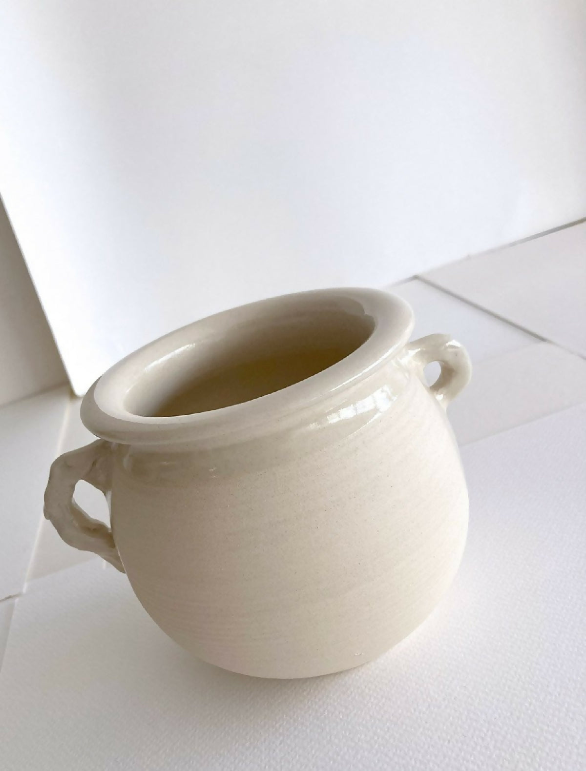 Pot en grès beige clair avec anses, ouverture large, vue rapprochée