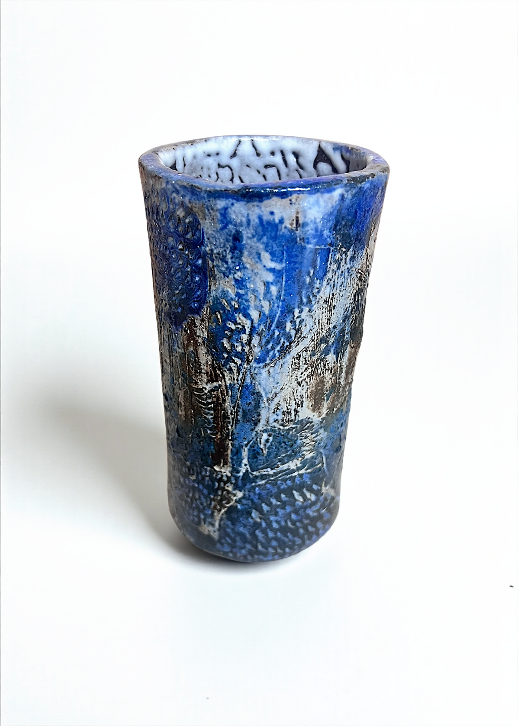 Petit vase cylindrique en grès bleu, bord supérieur texturé, effet patiné