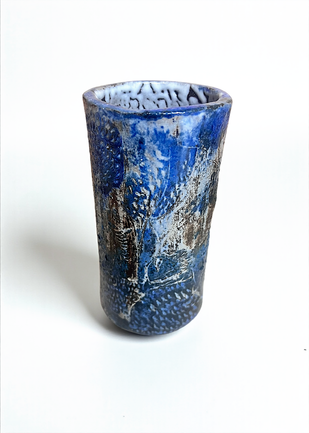 Petit vase cylindrique en grès bleu, bord supérieur texturé, effet patiné