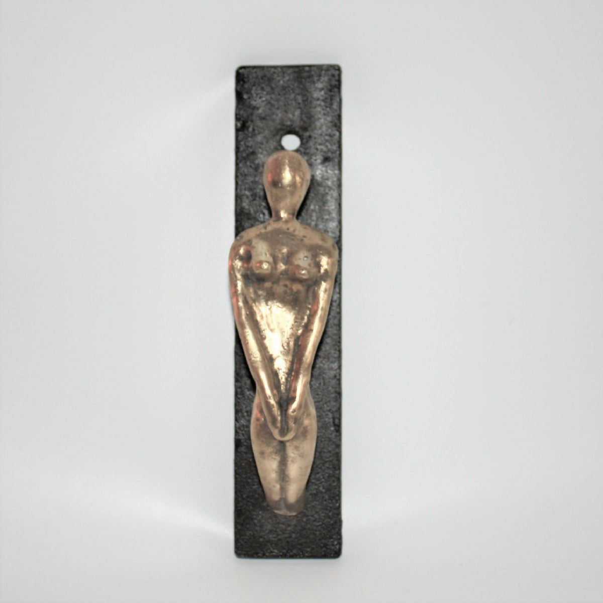 Porte-manteau mural avec figurine dorée sur plaque noire, anneau accroche-vestes.