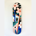 Skateboard décoré d’un visage et de fleurs stylisés, palette bleu, beige et noir.