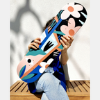 Skateboard illustré, motifs de visages et fleurs, couleurs vives bleu, orange et noir.
