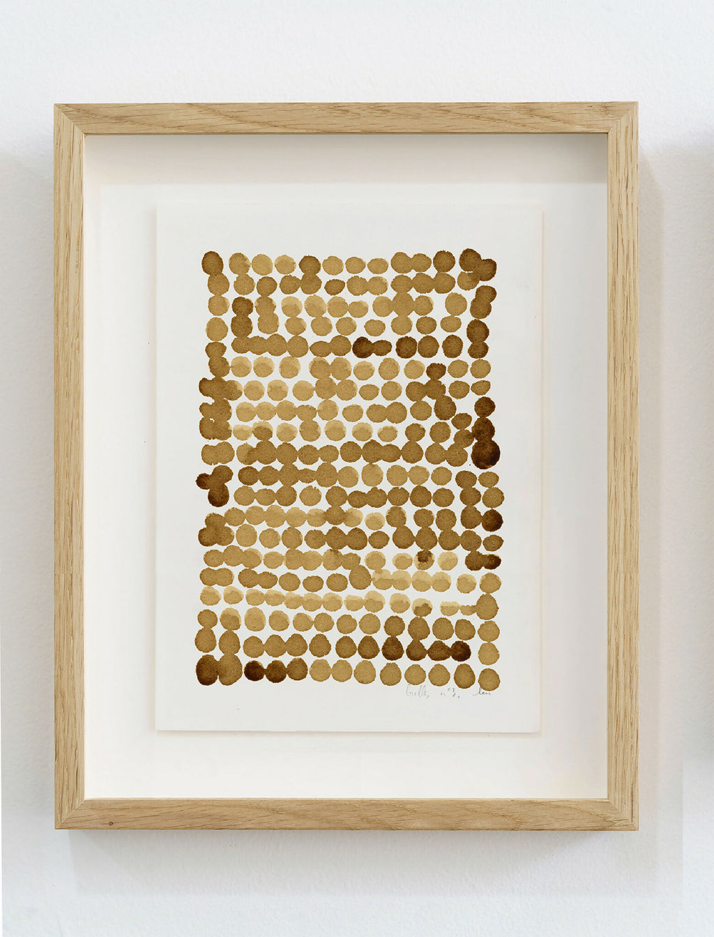 Encadrement en bois clair, peinture café sur papier: motif de bulles en points brun.