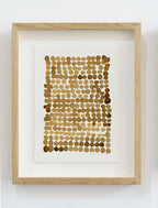 Encadrement en bois clair, peinture café sur papier: motif de bulles en points brun.
