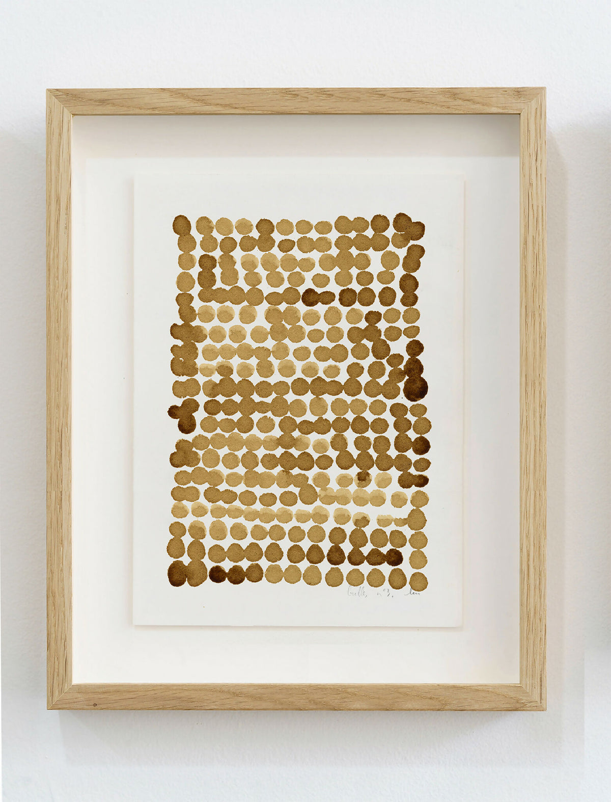 Encadrement en bois clair, peinture café sur papier: motif de bulles en points brun.