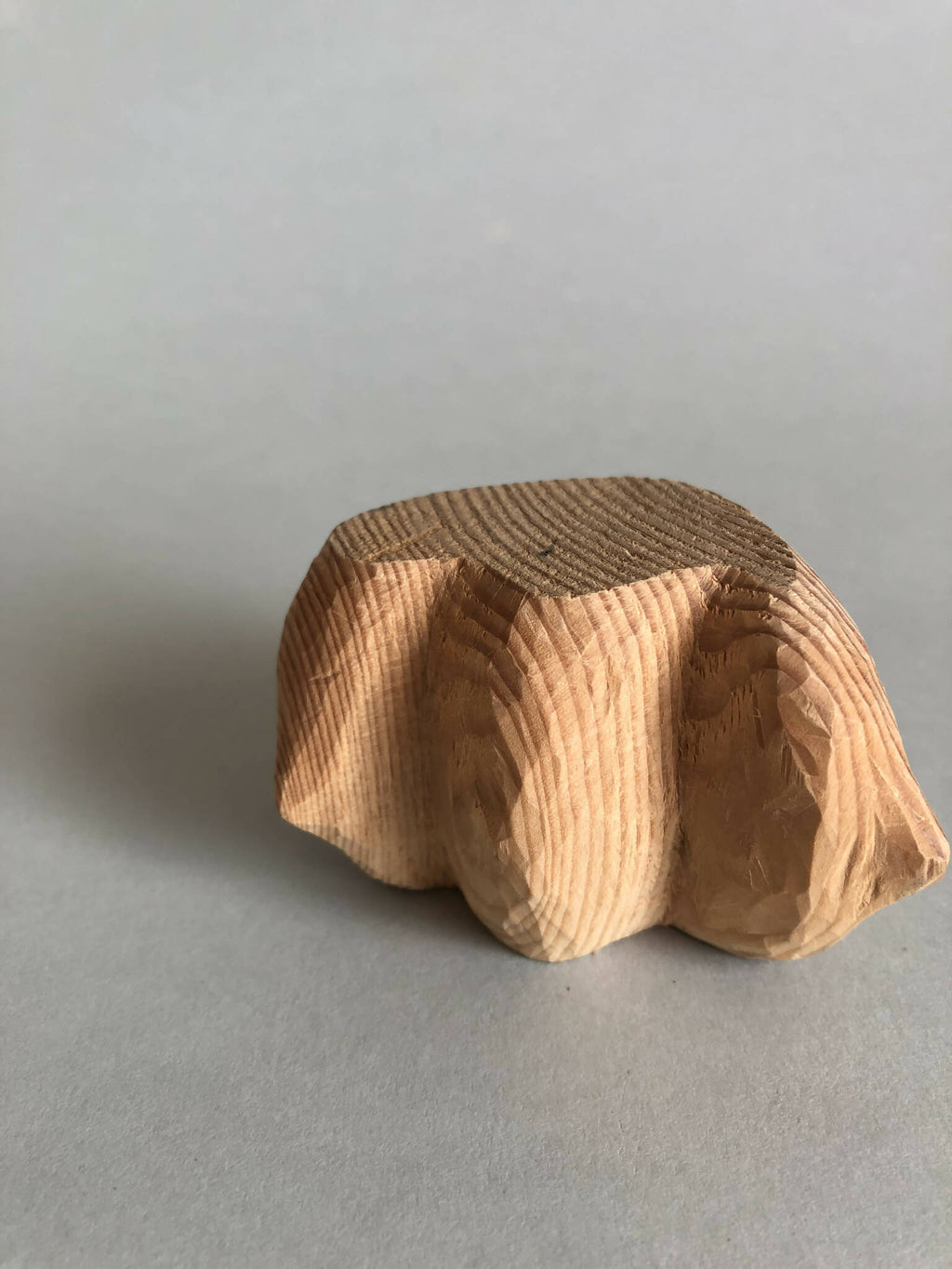 Petit socle sculpté brun et beige, relief strié, vue inclinée vers le haut