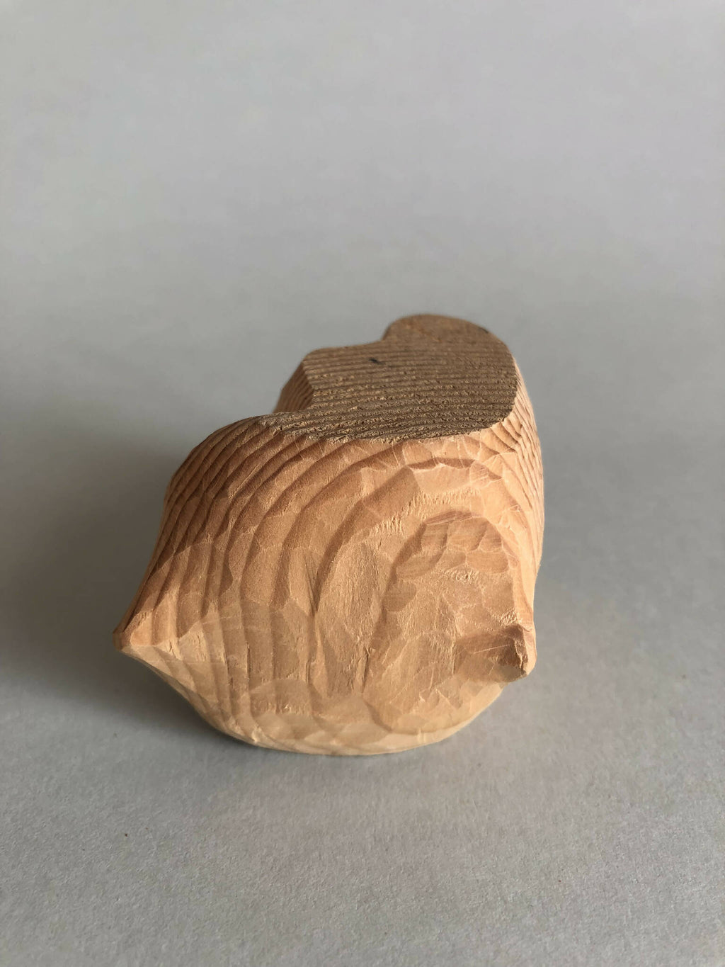 Petit socle sculpté beige avec dessus brun, relief en stries, forme arrondie