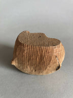 Petit socle sculpté brun, sommet en creux, relief strié sur toute la pièce