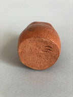 Petit vase en terre cuite orange, base arrondie, surface frottée.