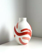 Petit vase buste blanc avec motifs abstraits rouge corail sur le devant.