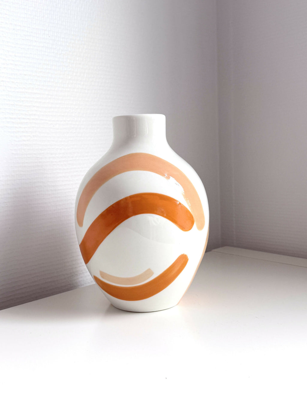 Petit vase blanc aux lignes corail, décor en arcs et angle trois-quarts