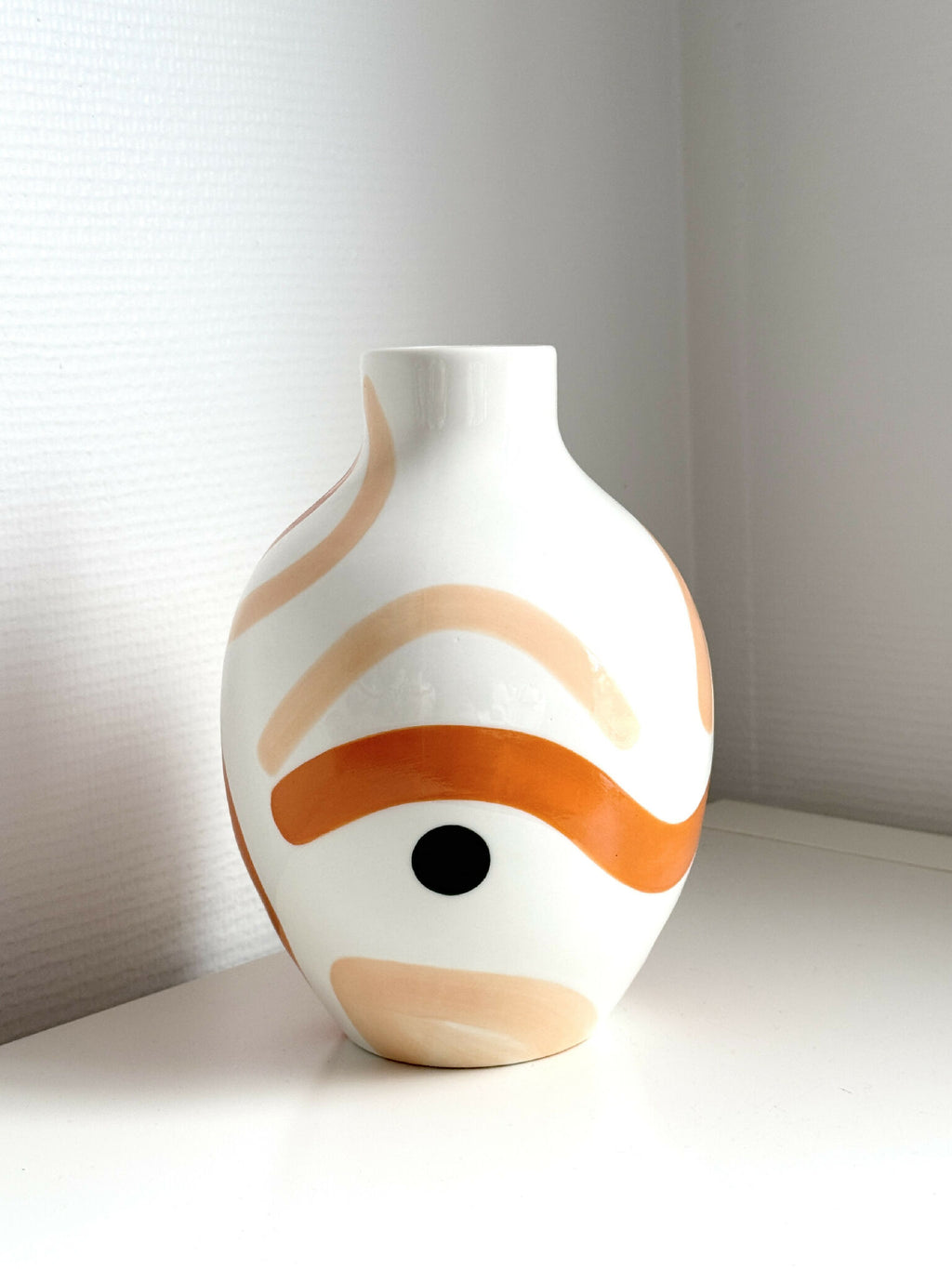 Petit vase blanc avec motif corail sur le buste et grand œil noir