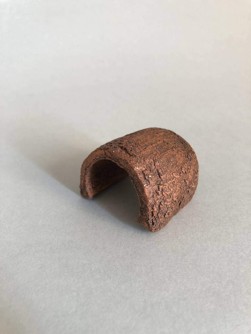 Petit objet concave brun, vue latérale de l’ouverture intérieure