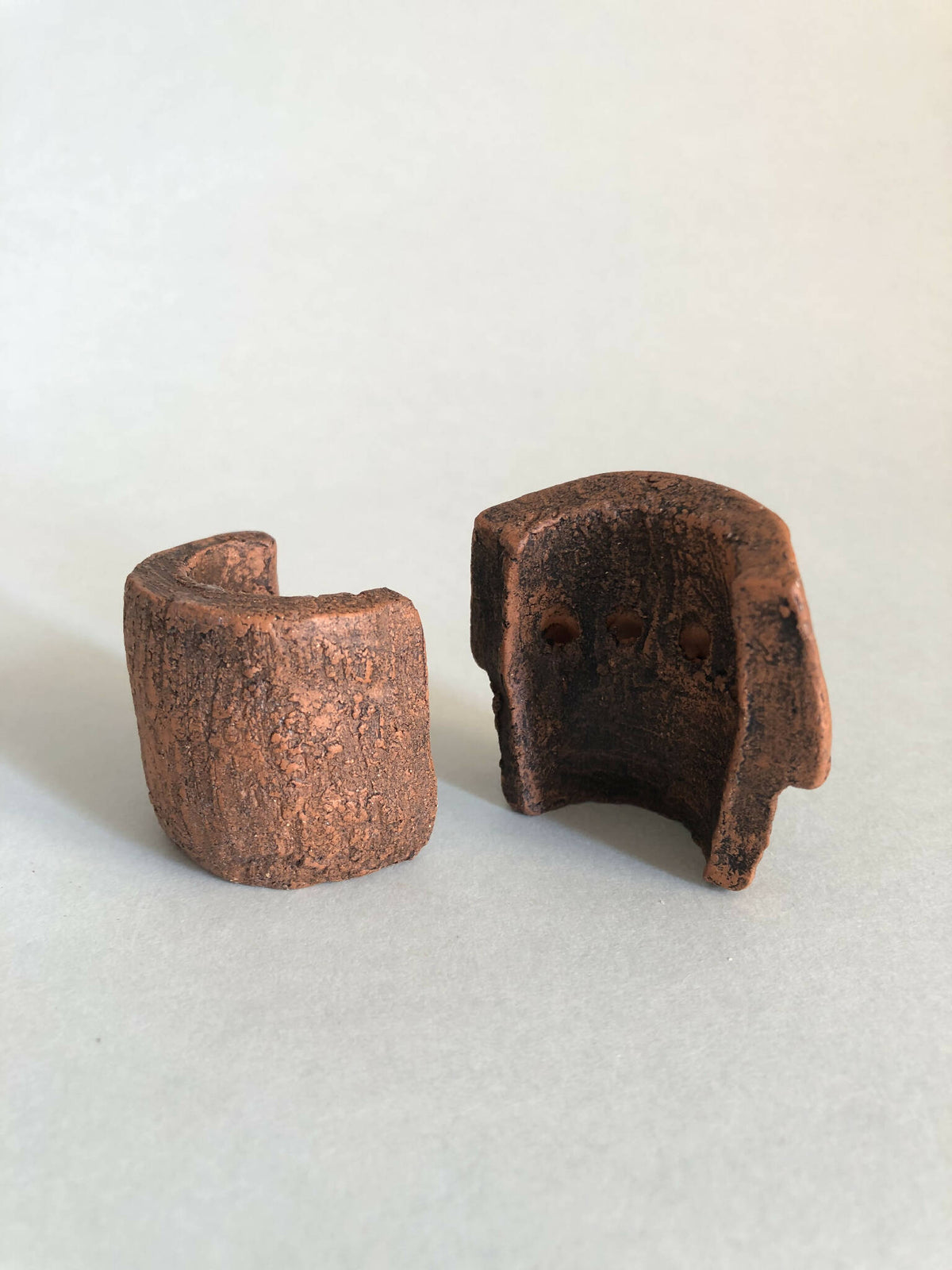 Deux petits objets concaves bruns texturés, ouvertures visibles