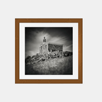 Photographie noir et blanc encadrée, chapelle de pierre sur une colline.