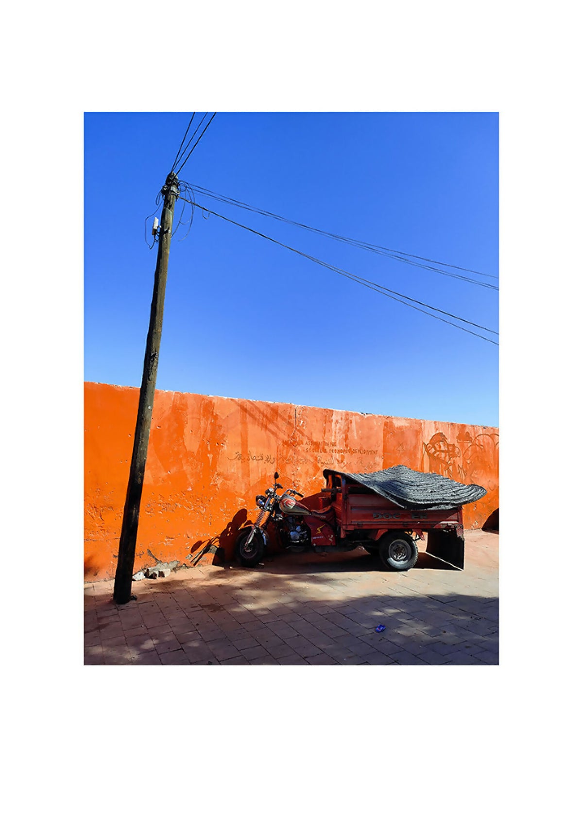 Photographie paysage orange et bleu, véhicule et poteau sur ciel bleu