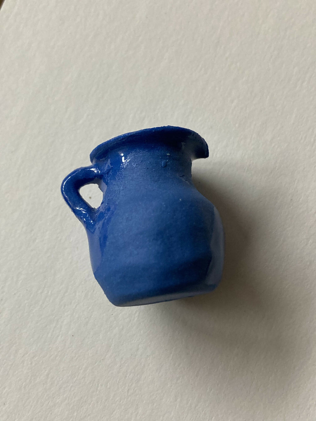 Pendentif miniature en porcelaine bleue en forme de pichet, vue rapprochée de l’anse
