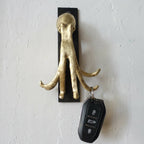 Porte-clés figurine pieuvre dorée avec télécommande noire pendante