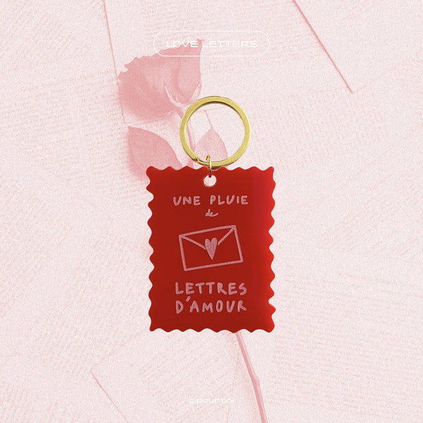 Porte-clés rouge « Une pluie de lettres d’amour » sur anneau doré.