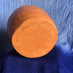 Pot en métal cuivré rouge, vue du fond avec marquage en relief.