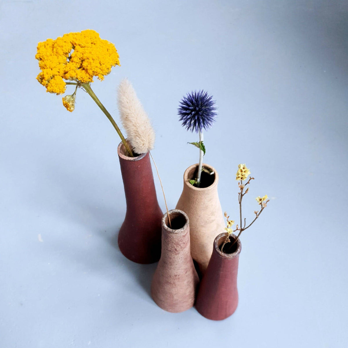 Quatre petits vases décoratifs bordeaux et beige, avec fleurs séchées