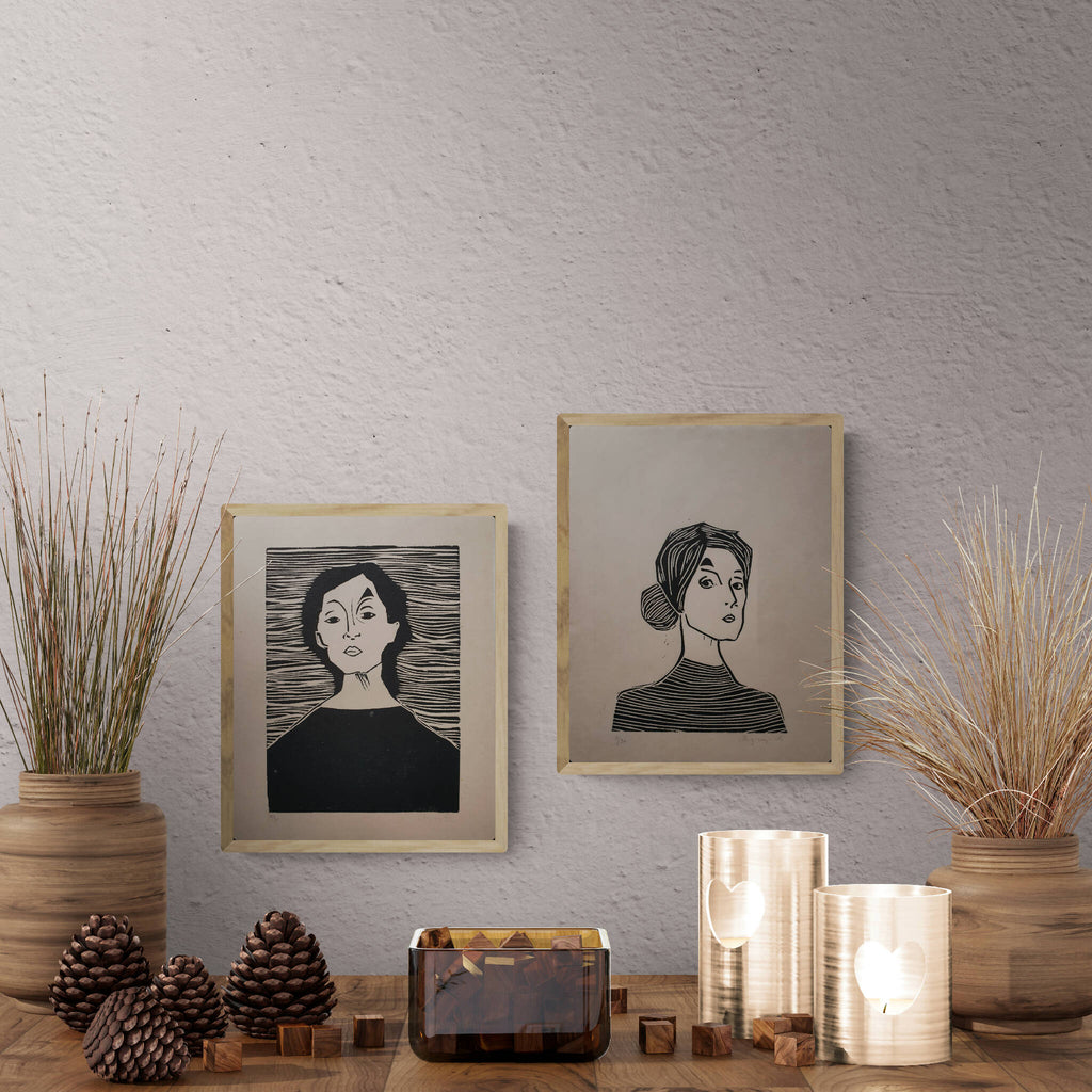 Deux affiches encadrées portrait de femme noir et crème, sur meubles