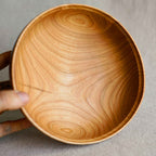Saladier en bois de noisetier vu de l’intérieur, veines en spirales et texture.