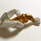 Sautoir homard doré, gros plan : corps doré et pinces blanches du pendentif
