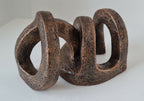 Sculpture abstraite en bois brun foncé, trois arches ajourées, effet texturé