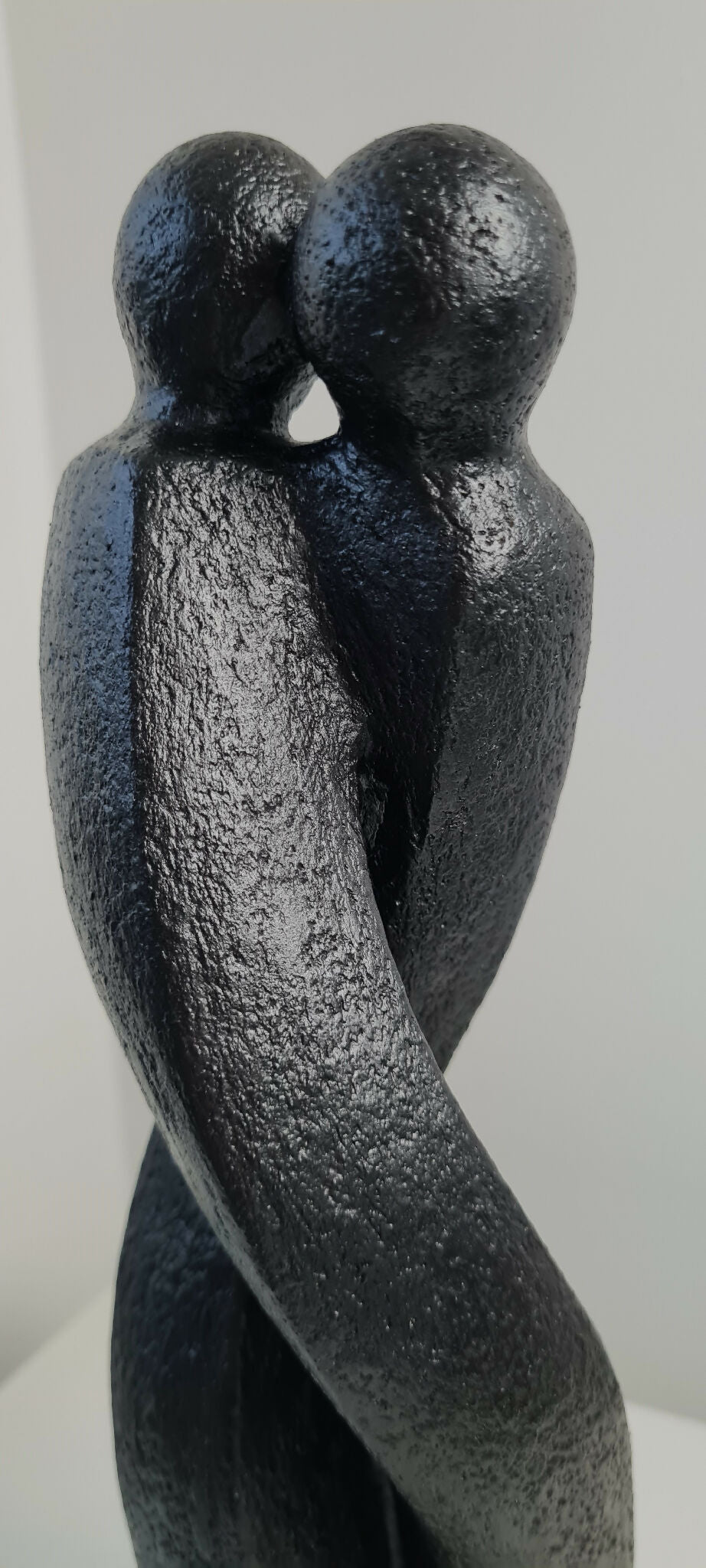 Sculpture en argile sombre : vue rapprochée de deux personnages qui se tiennent