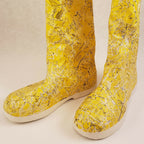 Bottes jaunes à tige haute, gros plan du motif, semelle blanche et couture visible.