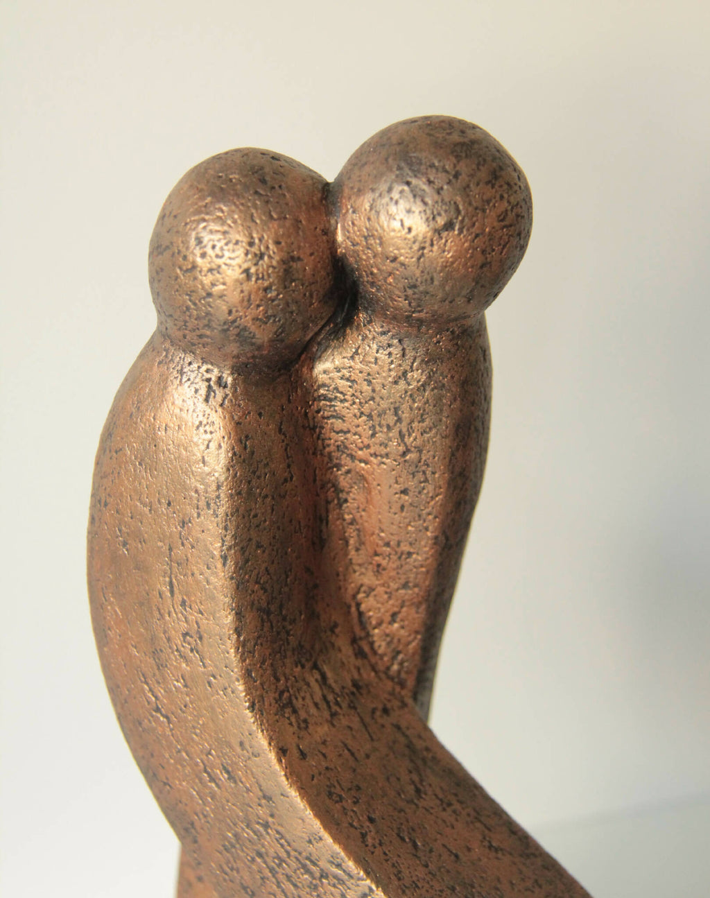 Sculpture abstraite en bronze patiné, deux têtes rondes enlacées sur une base