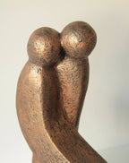 Sculpture abstraite en bronze patiné, deux têtes rondes enlacées sur une base
