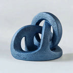Sculpture abstraite en résine bleue, formes d’anneaux empilés sur base.