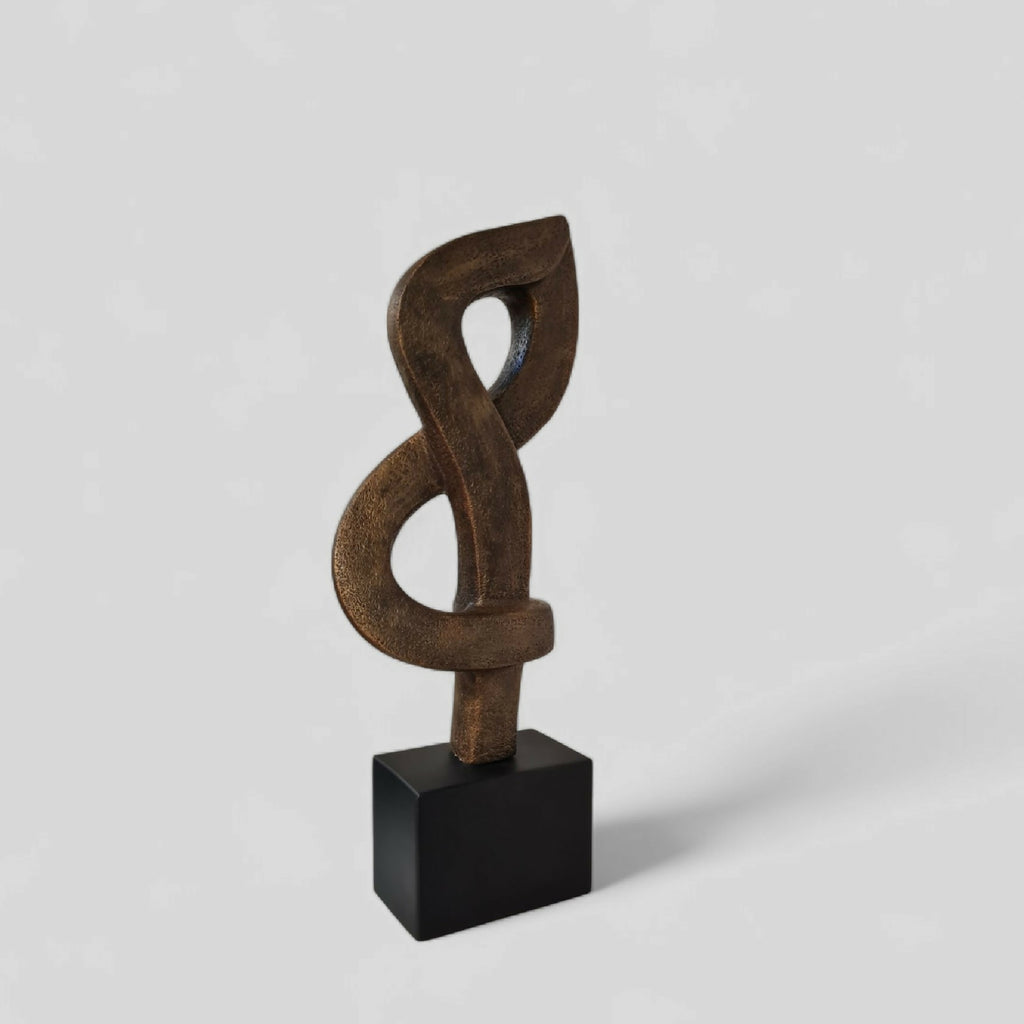 Sculpture abstraite en argile brun foncé, nœud entrelacé, sur socle noir.