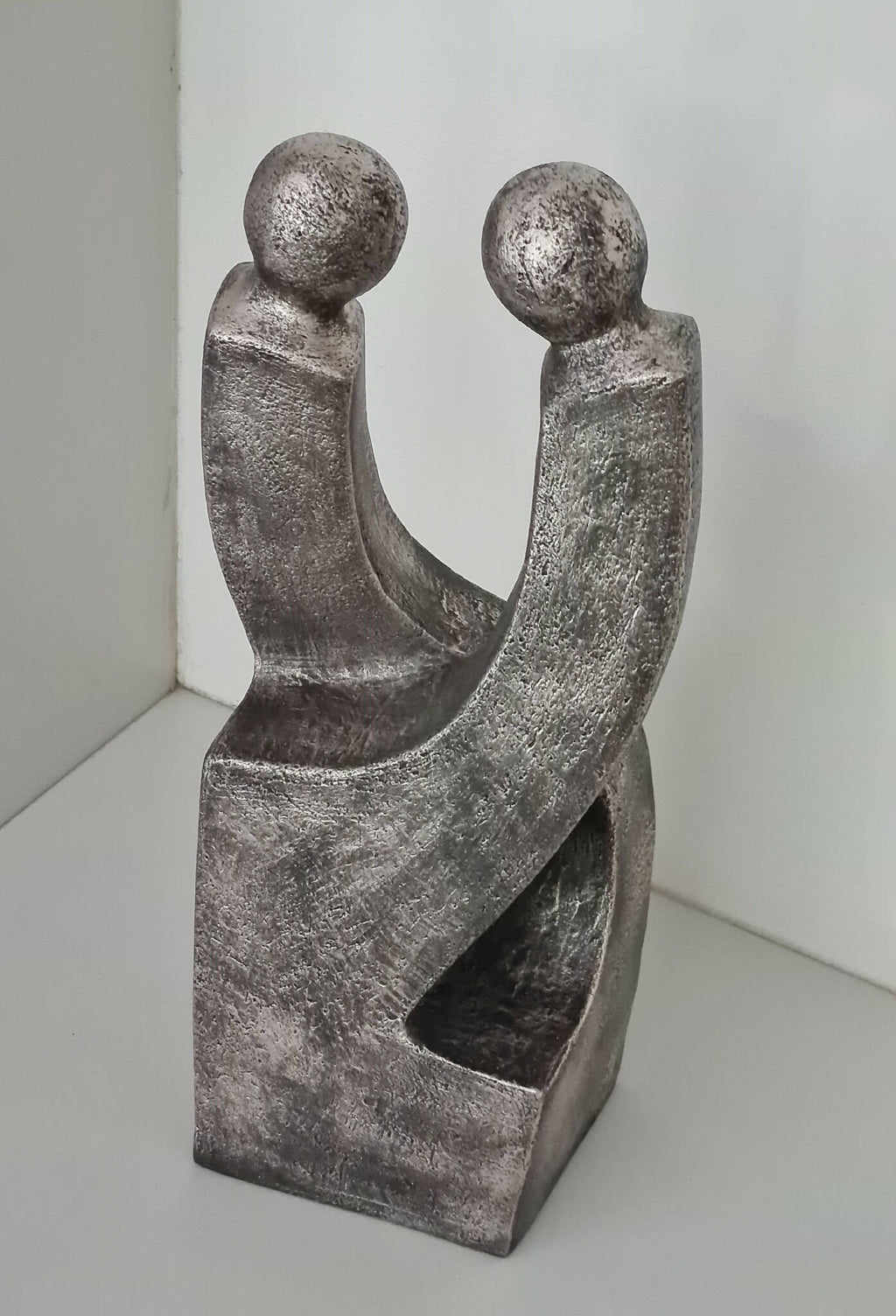 Sculpture de couple en métal gris argenté patiné, deux figures aux bras enserrés