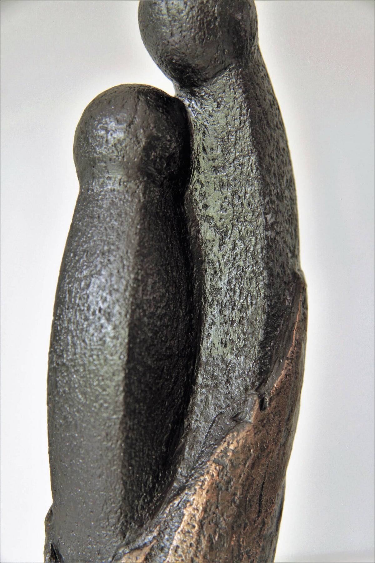 Sculpture couple en figurine : vue de côté des deux personnages, tons noir et doré.
