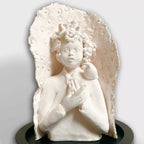 Sculpture en relief femme blanche agenouillée, oiseau dans les cheveux, sur base noire