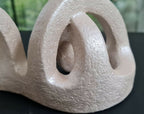 Détail sculpture en argile beige, anneau ajouré avec relief granuleux
