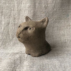 Petite sculpture en argile de chat, vue de trois-quarts, oreilles dressées.