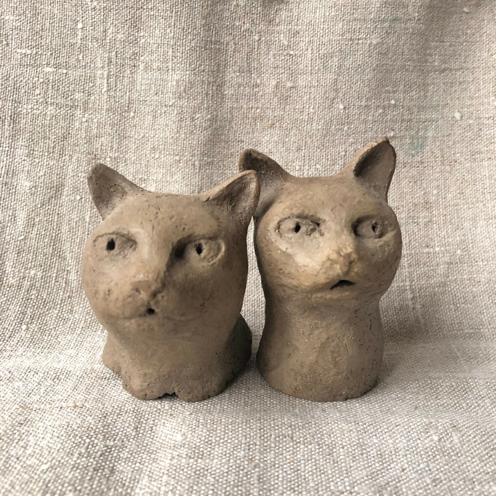 Paire de sculptures en argile de chats, deux petits félins assis côte à côte.