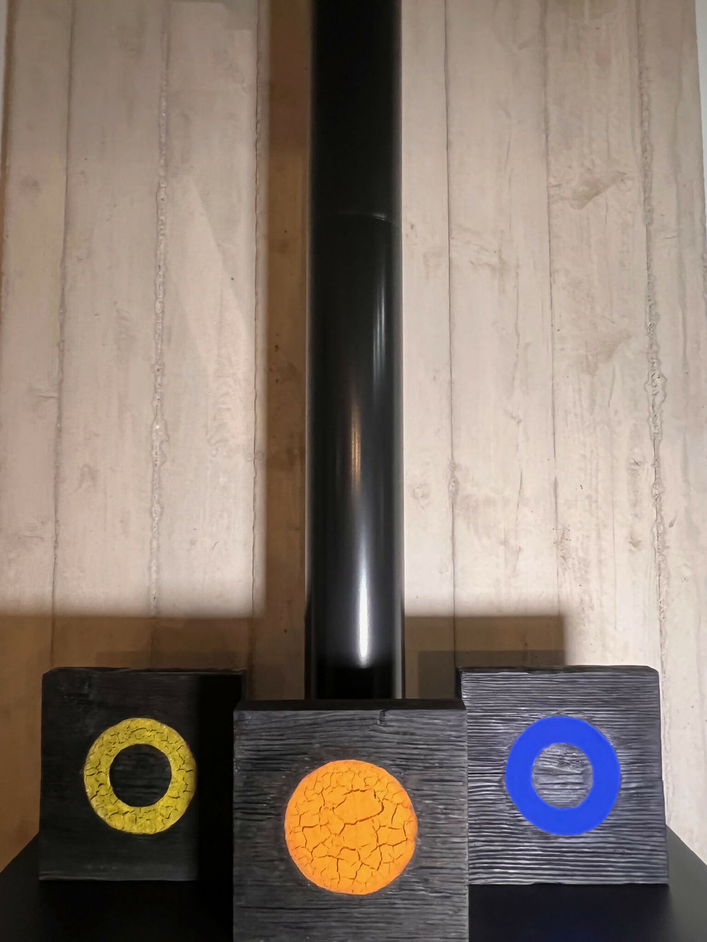 Ensemble de panneaux en bois sombres avec disques jaune, orange craquelé et bleu