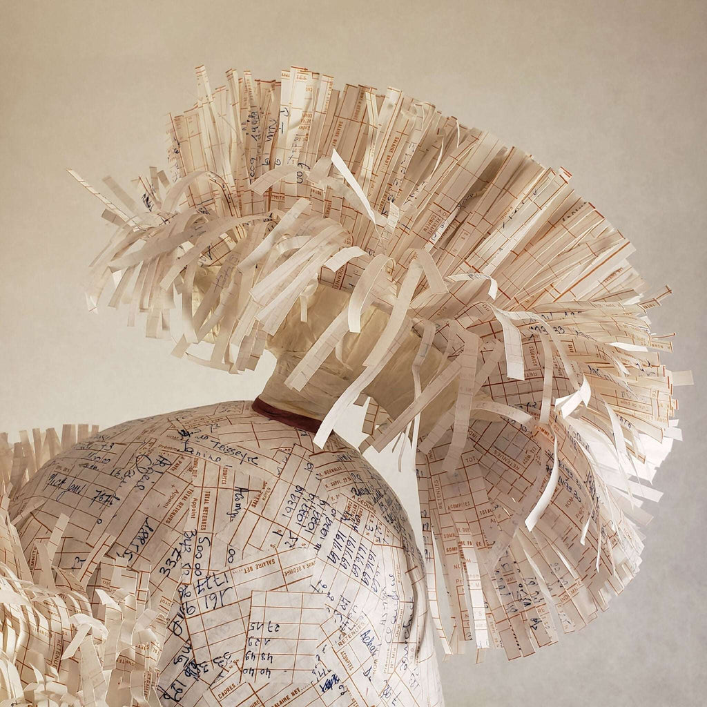 Casque à aigrette en papier imprimé beige, gros plan du plumet et du dos du chapeau.